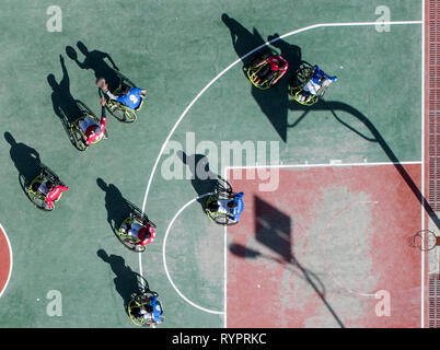 (190315) -- Lhassa, le 15 mars 2019 (Xinhua) -- photo aérienne prise le 3 mars 2019 montre les membres de l'équipe de basket-ball en fauteuil roulant de Lhassa en compétition durant un match à Lhassa, capitale de la Chine du sud-ouest de la région autonome du Tibet. Sous le soleil de mars, un match de basket-ball attire de nombreux participants à la périphérie de Lhassa, avec des joueurs de dribbler, tir, en passant, le vol et le rebondissement - dans leur fauteuil roulant. 'Dash ! Deyang !' Le public est enthousiaste et chants à voix haute. Le 21-year-old fille en bleu, l'usure se précipite son fauteuil roulant dans la cour après avoir obtenu un laissez-passer, et score Banque D'Images