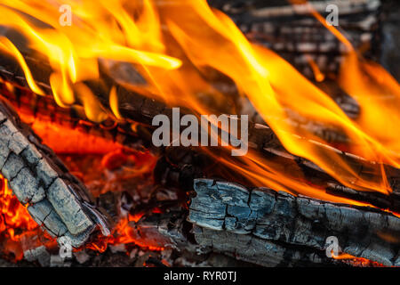 Droit de la combustion du bois de chauffage. Feu, flammes, bois carbonisé. Vue rapprochée. Réchauffement climatique et l'arrière-plan ou toile confortable Banque D'Images