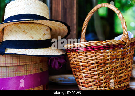 La nature morte avec vintage chapeaux de paille, coffret-cadeau, et un panier en osier. La mode Historique Banque D'Images