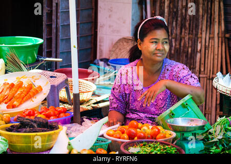 Une femme vend des légumes et des fruits dans 26th street market, Yangon, Myanmar Banque D'Images