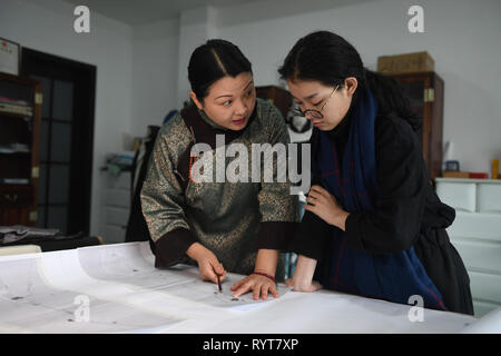 (190315) -- SHANGHAI, 15 mars 2019 (Xinhua) -- Fu Xianghong (L) et son élève il embridery Mengyuan discuter design en 101 dans la ville de Suzhou Wuzhong District, Province de Jiangsu Chine orientale, le 14 mars 2019. Xianghong Fu Fu Hanlu et sa fille ont été d'une longue lignée de broderie. En 2015, Fu Xianghong a été nommé en tant que représentant maître de Suzhou broderie, qui a été répertorié comme l'un des patrimoines immatériels de Suzhou. Ses œuvres de style unique combinant l'aspect pratique et l'art ont été présentés au cours de la Semaine de la mode de Beijing et Fashion Week de Paris. Sa fille a montré aussi Hanlu Fu Banque D'Images