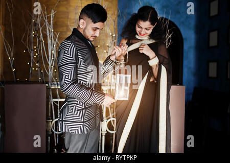 Happy diwali jour ! Joli couple indien dans l'amour, à l'usure et élégant costume, saree posés sur restaurant et organiser ensemble la lanterne. Banque D'Images