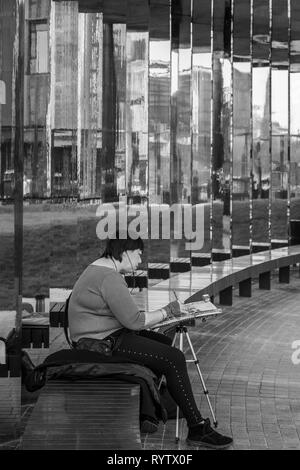 Une femme peintre travaillant à Hasholder Park, Kings Cross, London, UK.. Le miroir réfléchissant à côté allée. Appartements Tapisserie Banque D'Images