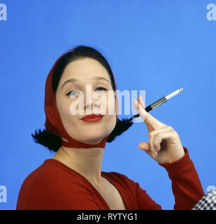 Les gens, les femmes, la femme en rouge wrap top, sous voile, tenant un fume-cigarettes, portrait, de la mode dans le style des années 50, Additional-Rights Clearance-Info-Not-Available- Banque D'Images