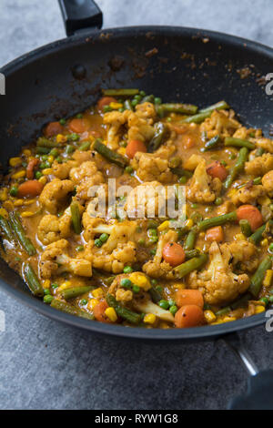 Curry de légumes indiens dans une poêle profonde. Cari de légumes indiens La cuisine. Korma de légumes masala cuisine dans un bol profond. Fond gris. Banque D'Images
