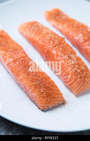 Close up of raw épicé et filets de saumon cru. Les morceaux de saumon sur une plaque blanche. Voir de très près. Saumon sain non cuites. Sashimi de saumon. Banque D'Images