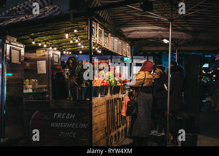 Londres, UK - 9 mars 2019 : Les gens d'acheter des fruits et des jus de Juicebox stall sur Oxford Street, Londres, dans la soirée. Oxford Street est l'un o Banque D'Images