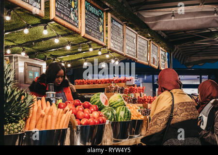 Londres, UK - 9 mars 2019 : Les gens d'acheter des fruits et des jus de Juicebox stall sur Oxford Street, Londres, dans la soirée. Oxford Street est l'un o Banque D'Images