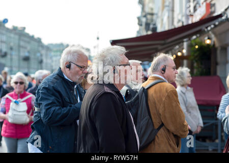 Les hommes âgés d'apparition sur une tournée en radio écouteurs guide sur la Perspective Nevski à Saint-Pétersbourg, Russie, septembre 2018. Vue de côté. Banque D'Images