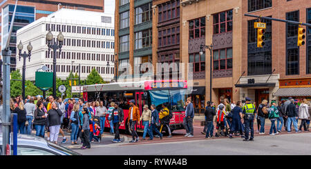 Grand Rapids, MI / USA - 0929 2018 : un officier de police veille sur une foule de personnes de traverser une rue à Grand Rapids au cours de ArtPrize 2018. Banque D'Images