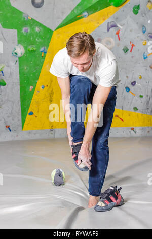 Rock climber met sur des chaussures dans un hall à une escalade escalade Banque D'Images