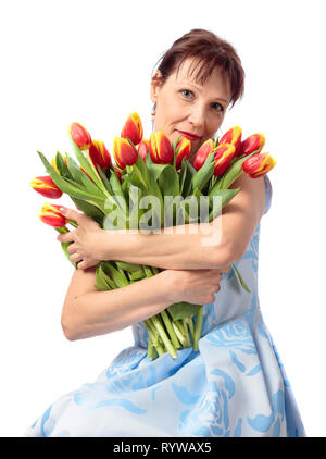 Belle femme d'âge moyen avec un bouquet de tulipes rouges et jaunes.isolé sur fond blanc. Banque D'Images