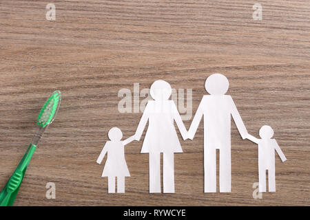 Concept de la famille de soins dentaires avec des éléments représentatifs et oral outils sur une table en bois brun. Composition horizontale. Vue d'en haut Banque D'Images