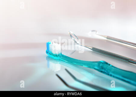 Dentiste blanc table avec brosse à dents bleu et d'outils. Composition horizontale. Elevated view Banque D'Images