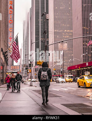 Une femme seule promenades à travers la ville de New York par une froide journée de l'hiver. Banque D'Images