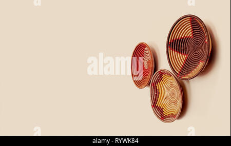 Paniers d'herbe rwandais décoratifs suspendus sur un mur. Articles de décoration d'origine d'Afrique de l'est magnifiques et colorés. Artisanat ethnique fait main. Banque D'Images