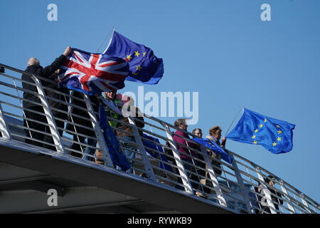 Les partisans pro-UE agitent des drapeaux du Gateshead Millennium Bridge sur la rivière Tyne à Newcastle Upon Tyne, bateaux de pêche comme l'affichage de drapeaux à l'appui du Brexit passer. Banque D'Images