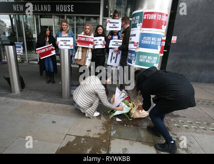 Les membres du public les tributs floraux et tenir son tour à l'amour des pancartes à l'extérieur de la Nouvelle-Zélande High Commission à Haymarket, Londres, à la suite de l'attaque de la mosquée à Christchurch. Banque D'Images