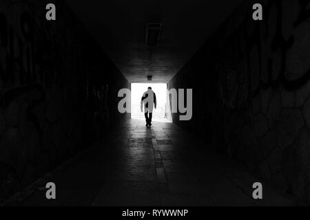 Homme marchant dans un passage souterrain Banque D'Images