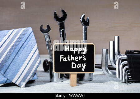 Ardoise avec Happy Father's Day Text entouré d'outils de travail et à la cravate de table en bois Banque D'Images