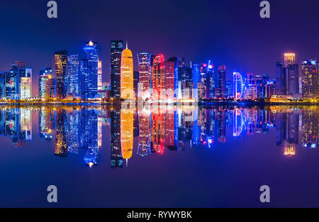 La capitale du Qatar par nuit. Doha West Bay skyline de refléter, dans la baie de Doha. Gratte-ciel vitré moderne de Doha au Qatar, le Moyen-Orient, l'Arabian Banque D'Images