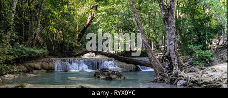 Panorama d'un belle cascade court avec une plage scrubby sur la droite dans la dense forêt de parc national d'Erawan en Thaïlande Banque D'Images