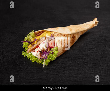 Avec tortilla viande de poulet frit, frites et salade sur fond noir Banque D'Images