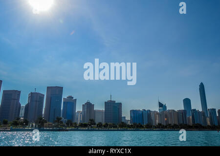 La ville d'Abu Dhabi Corniche le long beach prises à partir d'un bateau en eau Banque D'Images