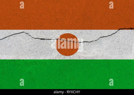 Niger drapeau sur mur de béton avec le crack. Grunge fond patriotique. Drapeau national du Niger Banque D'Images