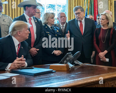 Le Président des Etats-Unis, Donald J. Trump, gauche, écoute-nous le Procureur Général William P. Barr, deuxième à droite, fasse une déclaration avant la signature du président de l'instruction de veto de loi adopté par le Congrès pour bloquer l'urgence nationale, il a déclaré plus tôt pour financer la frontière sud retardé mur dans le bureau ovale de la Maison Blanche à Washington, DC le vendredi, Mars 15, 2019. À l'extrême droite est le secrétaire américain de la Sécurité intérieure (DHS) Kirstjen Nielsen. Credit : Ron Sachs/CNP | conditions dans le monde entier Banque D'Images