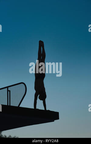 Handstand diver sur la plate-forme de plongée. Banque D'Images