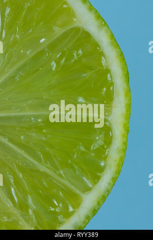 Tranche de Lime Gros plan sur fond bleu Banque D'Images
