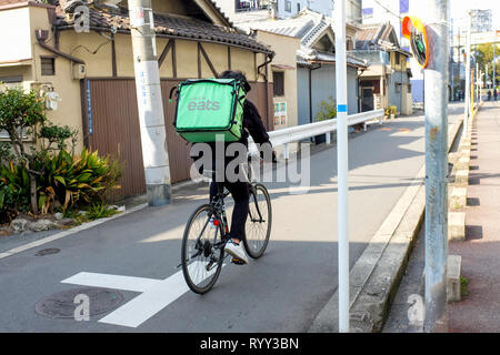Un livreur de Uber mange à Osaka, Japon. Banque D'Images