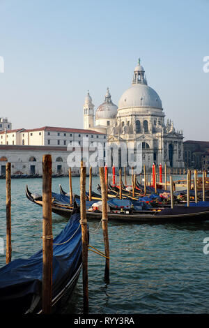 Goldolas lié aux pieux sur Grand Canal en dessous de Santa Maria della Salute, Venise, Italie Banque D'Images