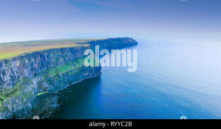 L'incroyable vue panoramique sur les falaises de Moher face à la grande mer à l'ouest de l'Irlande et le ciel bleu
