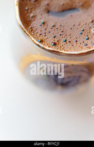Macro shot : isolés de café dans une tasse ronde - bulles pétille de Arc-en-ciel Banque D'Images