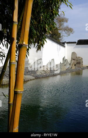 Rocaille par le miroir d'eau avec forêt de bambou en premier plan dans le jardin de Suzhou Museum conçu par I.M.Pei. Suzhou.La Province de Jiangsu en Chine. Banque D'Images