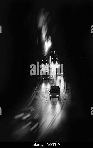 Les voitures qui circulent sous la pluie de nuit, flou, noir et blanc fond d'art, couverture de livre Banque D'Images