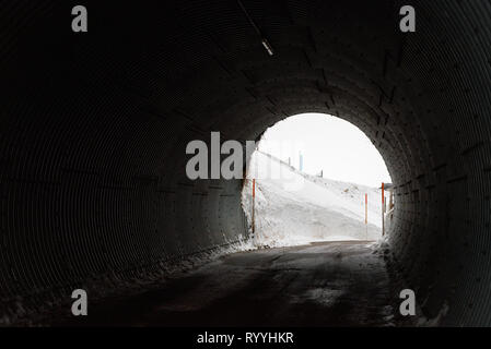 Sortie du tunnel en vue de neige élevée le long de la route, conditions hivernales sur la route de montagne Banque D'Images