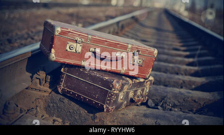 L'image de deux vieilles valises vintage jetée sur les rails de chemin de fer. Banque D'Images