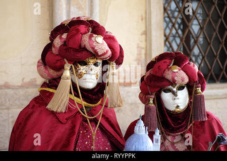 L'homme et de la femme habillée en costume traditionnel et masque de carnaval de Venise en vertu de l'article à l'arche du Palais des Doges, de la Piazza San Marco, Venice, Veneto, Itali Banque D'Images