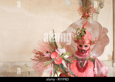 Homme habillé en costume traditionnel et masque de carnaval de Venise en vertu de l'article à l'arche du Palais des Doges, de la Piazza San Marco, Venice, Veneto, Italie Banque D'Images