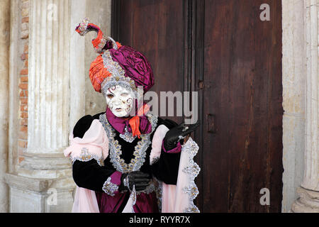 Femme vêtue de costumes traditionnels et de masque pour le Carnaval de Venise au comité permanent du Palais des Doges, de la Piazza San Marco, Venice, Veneto, Italie Banque D'Images