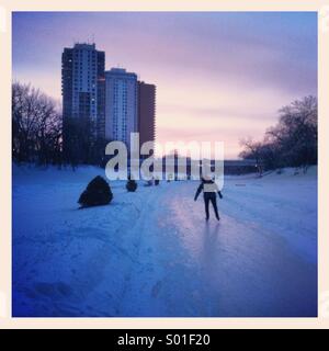 Patinage sur la rivière Assiniboine congelé au coucher du soleil, Février 2014 Banque D'Images