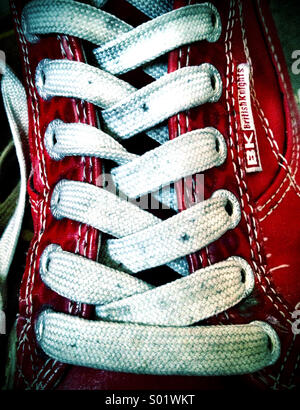 Close-up de lacets sur beat up red sneakers Banque D'Images