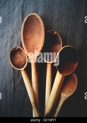 Belle vieille cuillères en bois pour la cuisine sur un fond d'ardoise. Banque D'Images