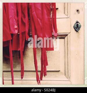 Costume rouge sur la vieille porte de bois Banque D'Images