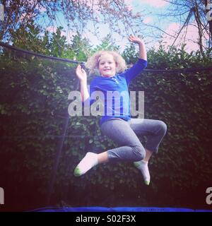 Jeune fille, de 9, de sauter sur un trampoline. Banque D'Images