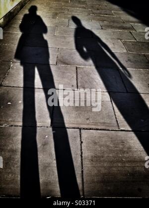 De longues ombres de deux femmes sur un trottoir Banque D'Images