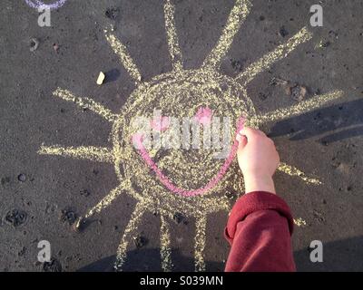 Peinture à la main avec un soleil souriant chalk Banque D'Images